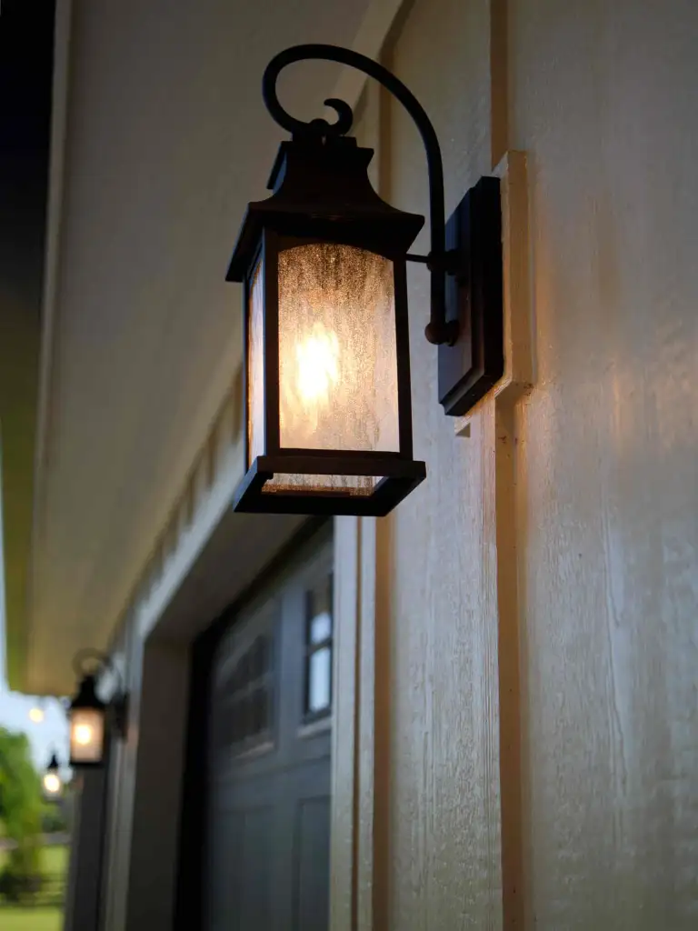 Lantern sconce on board-and-batten siding beside a dark garage door, in Williamson County, Tennessee